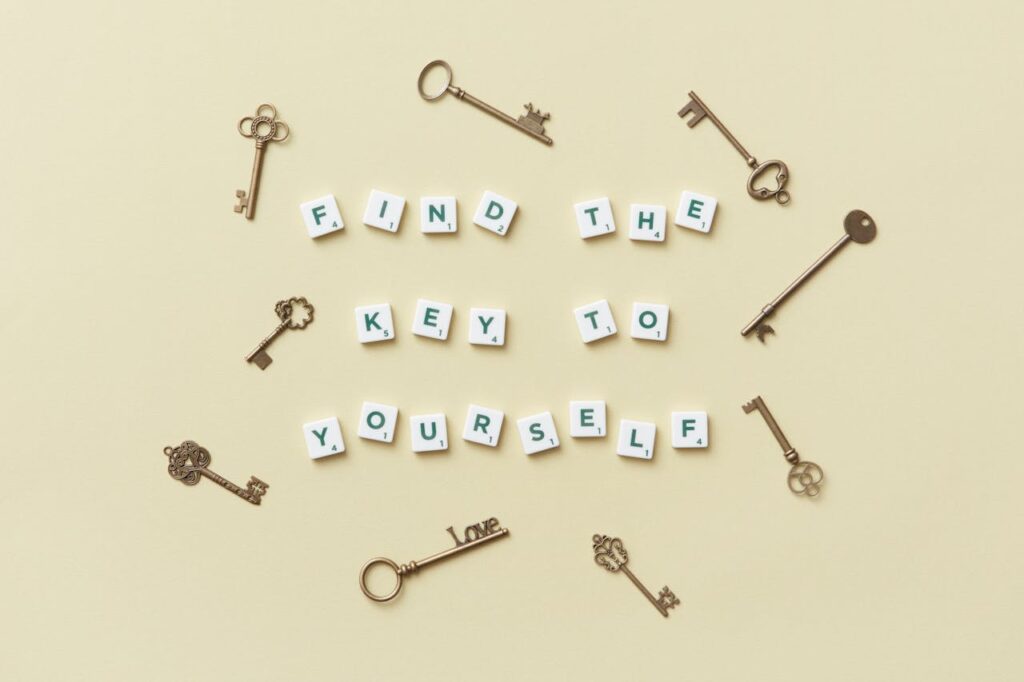 Creative arrangement of vintage keys and motivational text 'Find the key to yourself'.